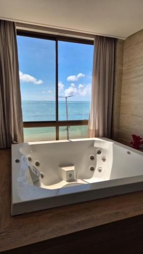 a bath tub with a view of the ocean at Niníve Boutique Hotel in Cabedelo