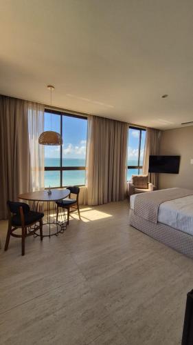 a hotel room with a bed and a table and chairs at Niníve Boutique Hotel in Cabedelo