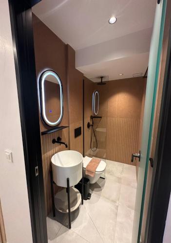 a bathroom with two toilets and a sink and a mirror at Perdika Ionion Villas in Perdika