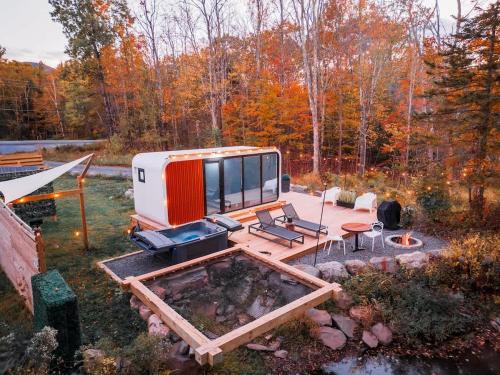 an rv sitting on a deck in the woods at Romantic tiny Pod for Two HotTub Pond FirePit in Haines Falls