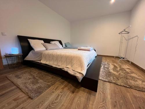 a bedroom with a large bed and a wooden floor at Casa do Rio in Freixieiro de Soutelo