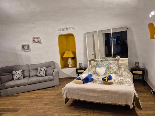 a bedroom with a bed with a couch and a mirror at Finca Naturacanaria in Moya