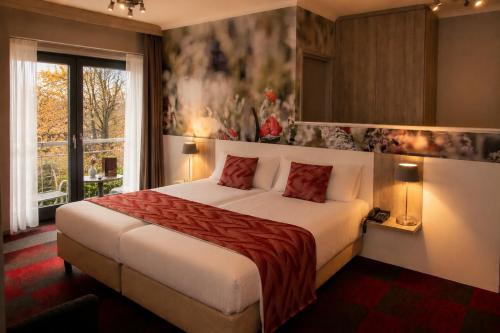 a bedroom with a large bed and a window at Hotel Hof van Gelre by Flow in Lochem