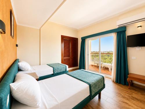 a hotel room with two beds and a window at St George Hotel - The Zoo in Cairo