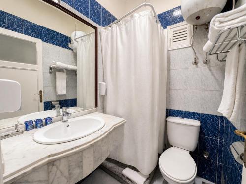 a bathroom with a white toilet and a sink at St George Hotel - The Zoo in Cairo