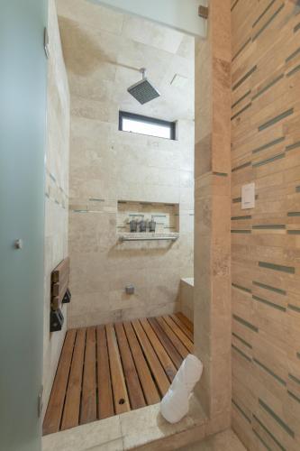 a bathroom with a shower with a wooden floor at Rooftop Oasis Steps from the Malecon in La Paz