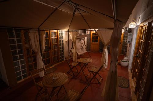 a room with chairs and tables and an umbrella at Karrizo lodge in San Pedro de Atacama