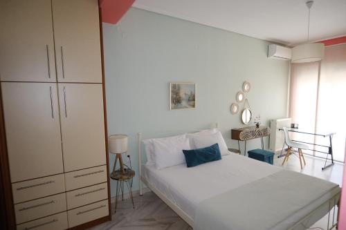 a bedroom with a white bed and a dresser at La maison de Catherine in Volos
