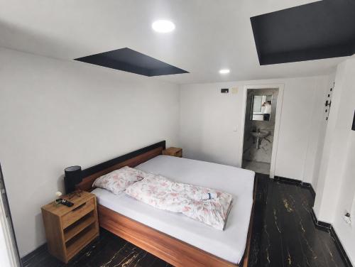 a small bedroom with a bed and a night stand at Porto Apartmani in Zvornik