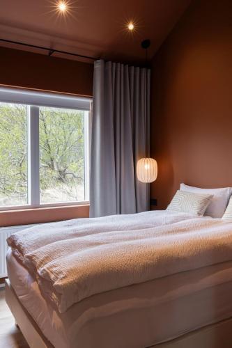 a bedroom with a large bed and a window at Modern Cabin with Hot Tub & Mountain views in Varmaland