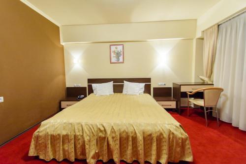 a hotel room with a bed and a desk at Hotel Severus in Zalău