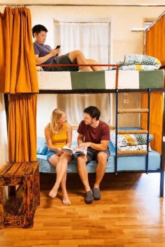 a group of people sitting on a bunk bed at The Friends Hostel & Sauna in Kutaisi