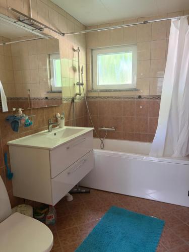 a bathroom with a sink and a tub and a toilet at Omran House in Ystad