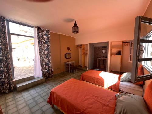 a hotel room with two beds and a window at Riad Dar Laure in Taroudant