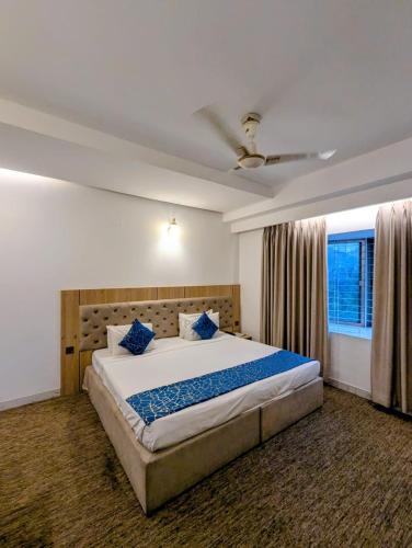 a bedroom with a large bed and a window at Laurel Lakefront Hotel in Dhaka