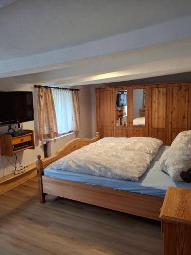 a bedroom with a large bed and a television at Haus Semmelrodt in Witzenhausen