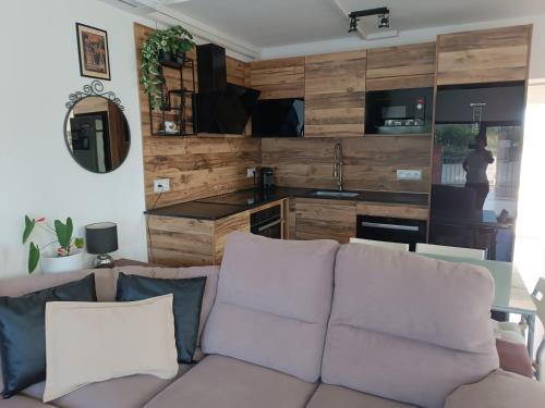 a living room with a couch and a kitchen at Suite Poblamar in Pobla de Montornés