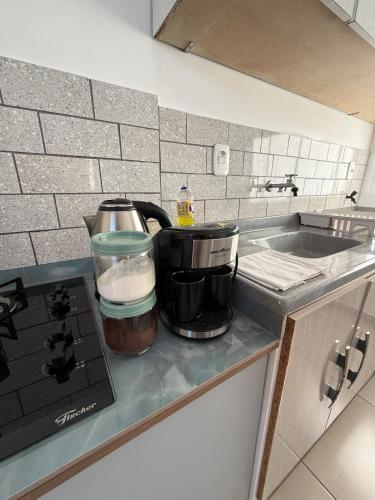 a kitchen counter with a coffee pot on a stove at Studio Planejado no Centro de Campos Novos in Campos Novos