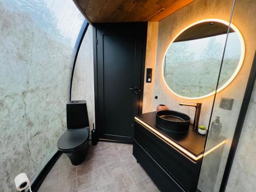 a bathroom with a sink and a round mirror at Lofoten Aurora Dome in Hanøya
