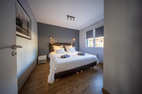 a bedroom with a bed with white sheets and pillows at residence kersailliou in Roscoff