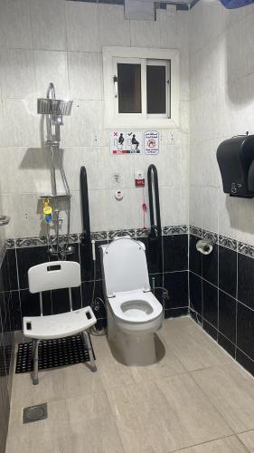 a bathroom with a toilet and a chair in it at Johraat Taba Tourist Hostel in Medina