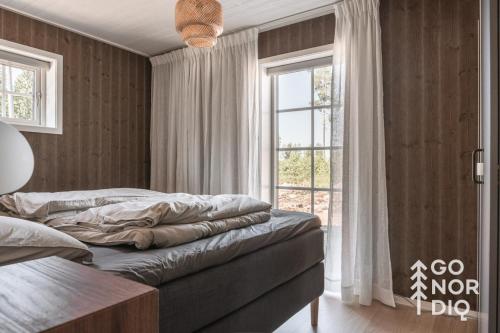 a bedroom with a bed and a large window at Bluebirch Cabin in Tällberg