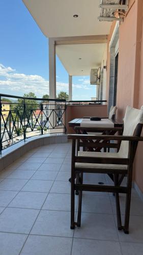 a balcony with a table and a bench on a balcony at Heleni's Apartment in Aridaia