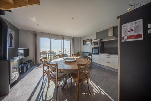 a kitchen with a table and chairs in a room at residence kersailliou in Roscoff