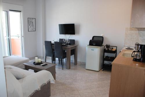 a living room with a couch and a table with a television at Heleni's Apartment in Aridaia