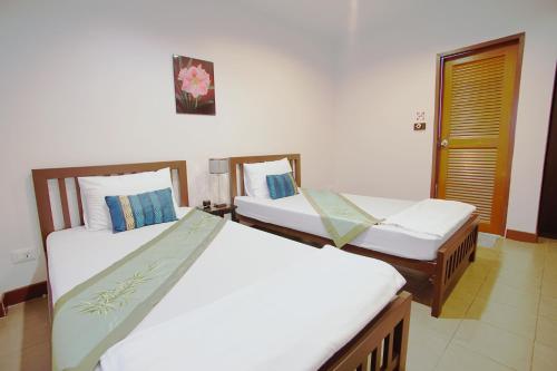 two beds in a hotel room with twothirdsessions at Ming Shou Boutique House in Phuket Town