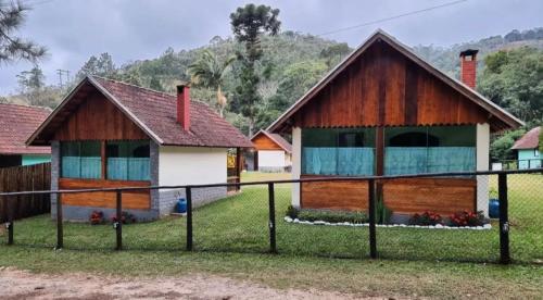 a house with a fence in front of it at Palmeira Azul in Visconde De Maua