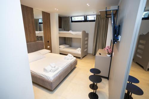 a small room with a bed and two bunk beds at Emili Premium Residence in Qeparo