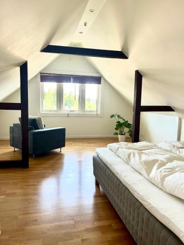 ein Schlafzimmer im Dachgeschoss mit einem Bett und einer Couch in der Unterkunft Sommerfryd in Oslo
