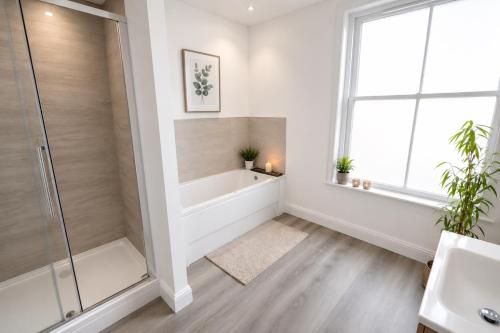 a bathroom with a shower and a bath tub at Seascape Seaview Apartment hot tub hire subject to availability in Scarborough