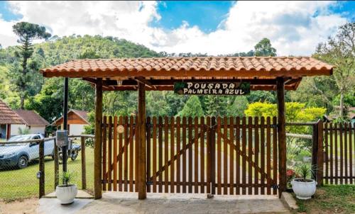 a gate to a parking lot with a sign on it at Palmeira Azul in Visconde De Maua