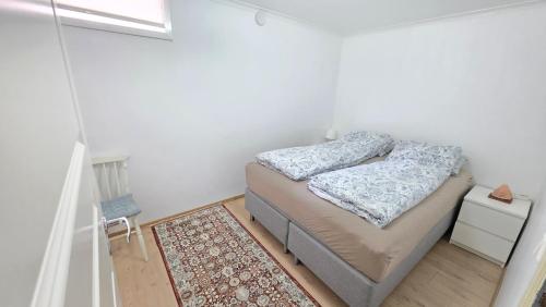 a small bedroom with a bed and a rug at Gjestehus i Tveit in Kristiansand