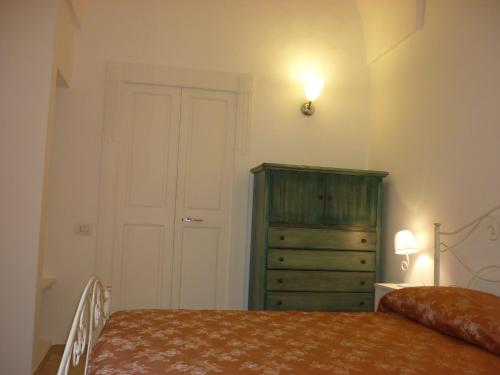 サンニコーラにあるDimora Montesantoのベッドルーム(緑のドレッサー、ベッド付)