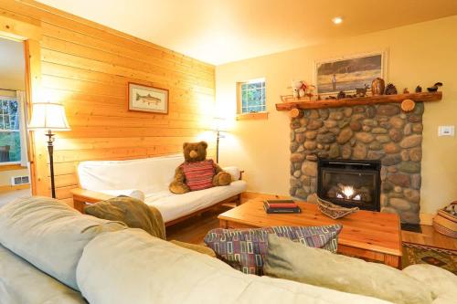a teddy bear sitting in a living room with a fireplace at Twin Lakes Cabin in Glacier