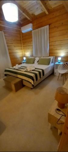 a bedroom with a large bed in a wooden room at Villa Mareta in Svoronata