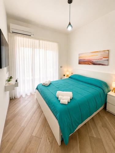 a bedroom with a large bed with a blue blanket at Sul Mare Apartment - Seafront with Sea View in Salerno