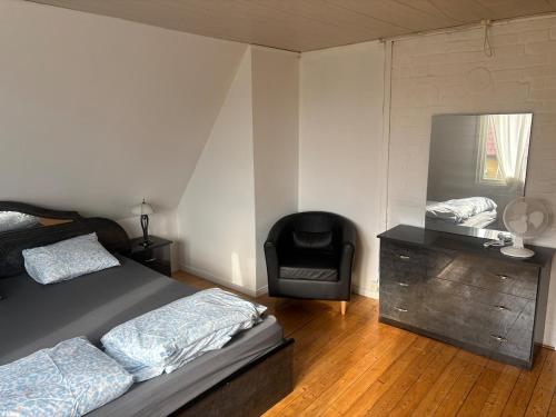 a bedroom with a bed and a chair and a mirror at Villa in Kvidinge