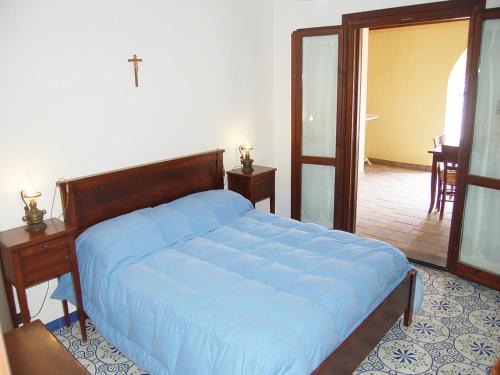 a bedroom with a bed with a blue comforter at Hotel Al Togo Fitness & Relax in Vulcano