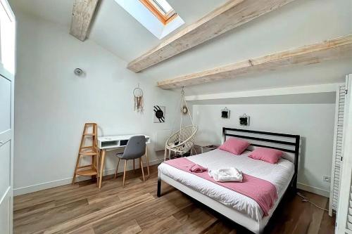 a bedroom with a bed with pink sheets and a desk at Maison Loft atypique - Jacuzzi clim et jardin in Saint-Jean-de-Védas