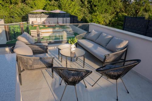 a patio with a couch and chairs and a table at Villa Bella in Čitluk