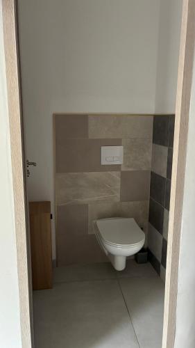 a bathroom with a white toilet in a room at maisonnette in Menglon