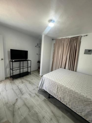 a bedroom with a bed and a flat screen tv at Las Palomas Residences in San Juan