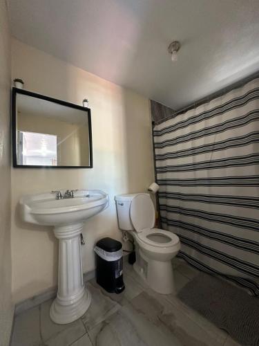 a bathroom with a sink and a toilet and a mirror at Las Palomas Residences in San Juan