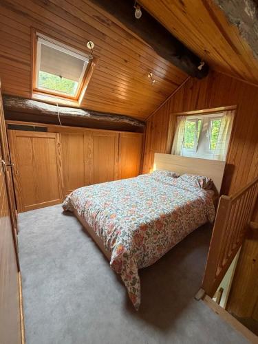a bedroom with a bed in a wooden house at Le Petit Fournil d'Aywaille in Aywaille
