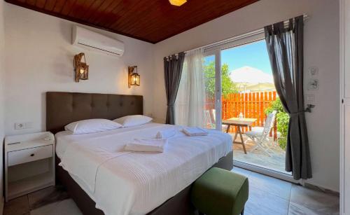 a bedroom with a bed with a view of a patio at Satsuma Butik Otel in Seferihisar
