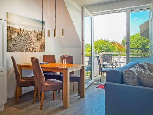 a dining room with a table and a couch at Tordalk 09 in Prerow